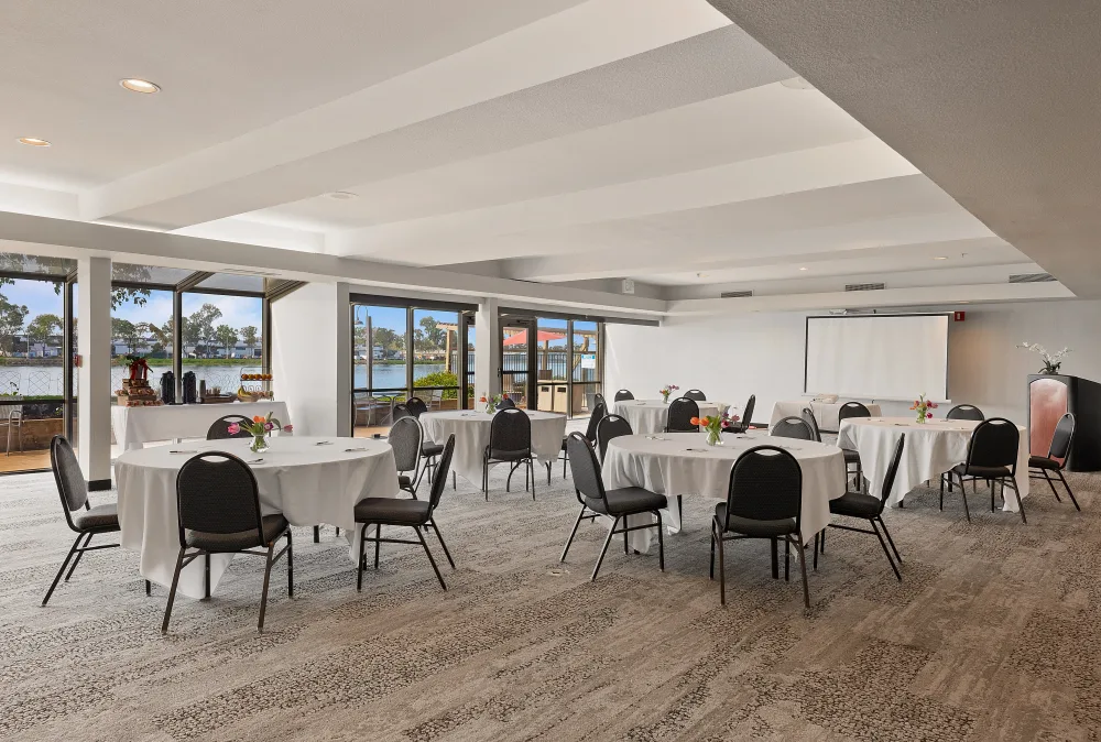 Event space at Executive Inn & Suites with networking tables and a water view